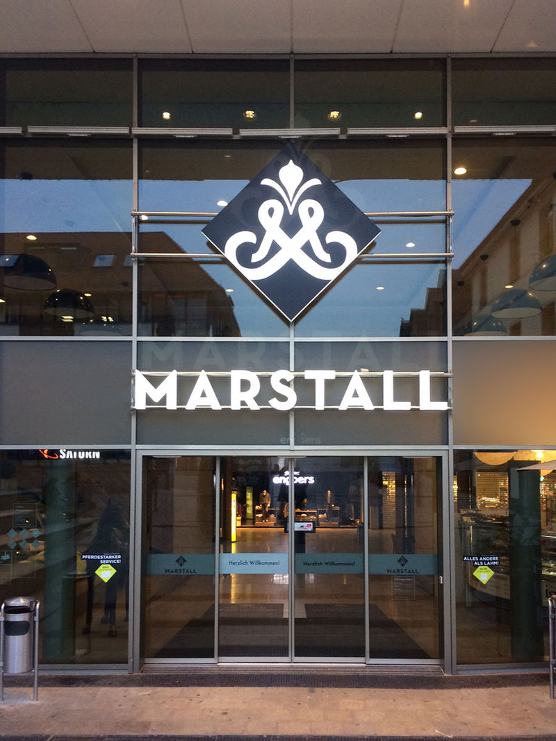 Marstall LED Lichtwerbung mit Logo an einem Verglasten Eingang.