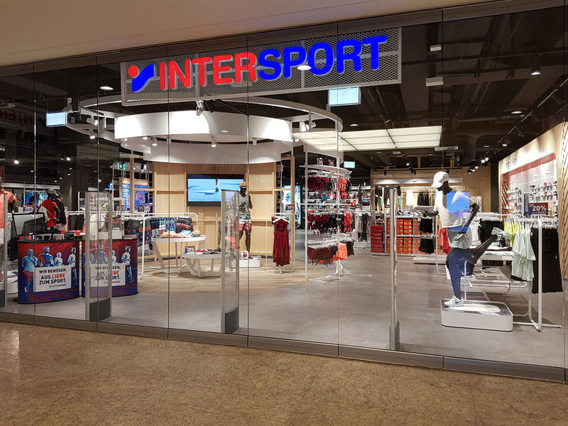 Glaseingang des Intersport Shops, inklusive Intersport Logoschild.